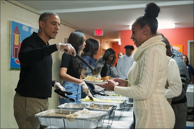 On left President Obama Malia Obama and first lady Michelle Obama serve Thanksgiving dinner during