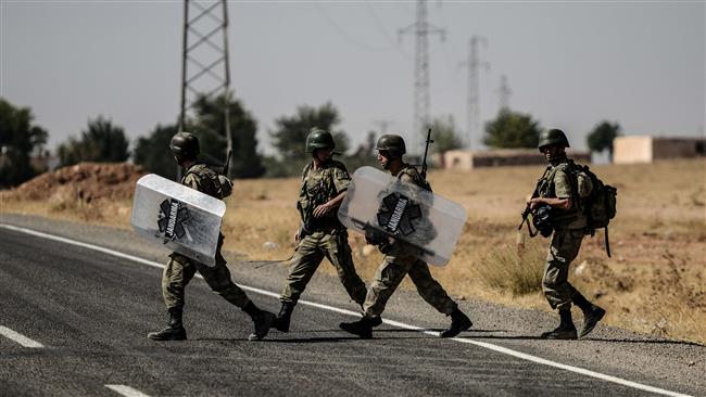 Turkish soldiers walk near the Turkey Syrian border post in Sanliurfa