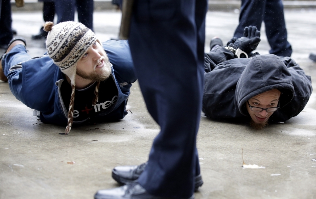 Two men are detained near Pioneer Court on Friday Nov. 27 2015 in Chicago. Community activists and labor leaders held a demonstration billed as a'march for justice in the wake of the release of video showing an officer fatally shooting Laquan McDonal