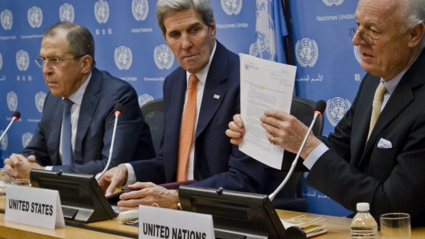 UN special envoy for Syria Staffan de Mistura  shows a copy of the Security Council resolution on Syria during a press conference with Russian Foreign Minister Sergey Lavrov and US Secretary of State John Kerry