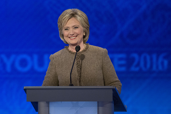 Hillary Clinton former Secretary of State and 2016 Democratic presidential candidate smiles after walking on stage following a break in the Democratic presidential candidate debate at Saint Anselm College in Manchester New Hampshire U.S. on Saturday