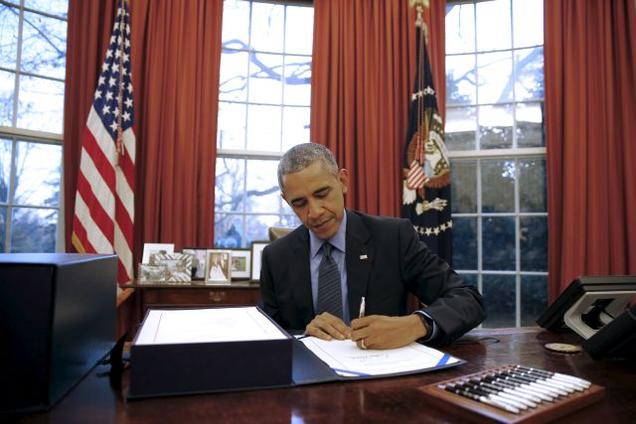 US President Barack Obama signs the $1.1-trillion Government Funding Bill into law at the oval office at the White House in Washington on Friday.- Reuters