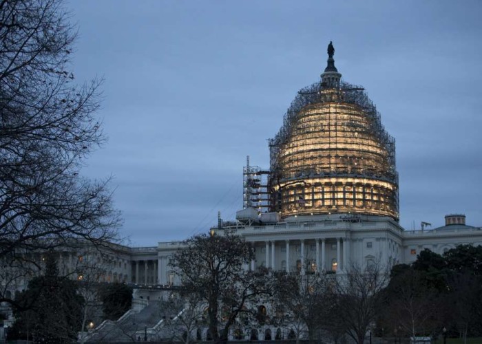 The Capitol Dome is illuminated amid scaffolding for repairs in Washington Friday morning Dec. 18 2015. The House and Senate race to wrap up votes on a massive spending and tax package which President Barack Obama promises to sign. (AP