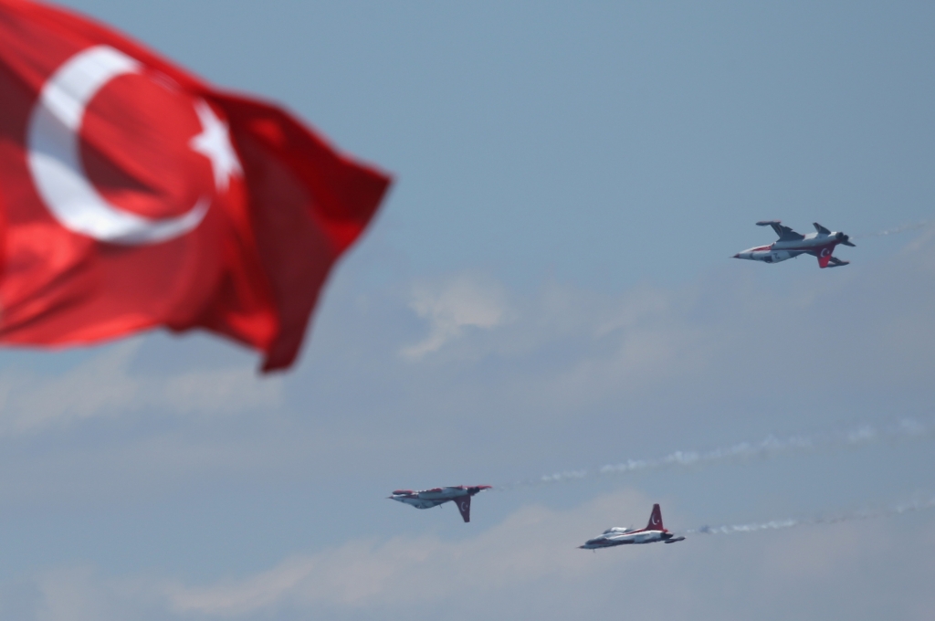 Planes of the Turkish air force fly in formation past a Turkish flag at Helles Point where Allied soldiers fought during the Gallipoli Campaign