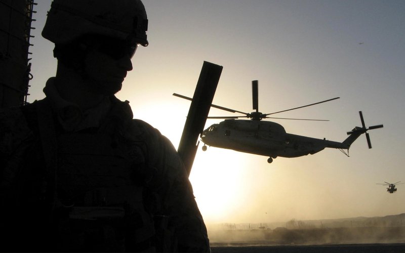A U.S. marine watches as helicopters fly in Sangin district of Helmand province
