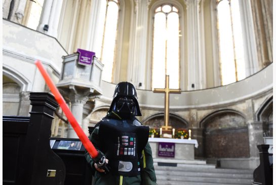 A person dressed as Darth Vader with a light saber stands in front of the altar inside the Zion church in Berlin on Sunday