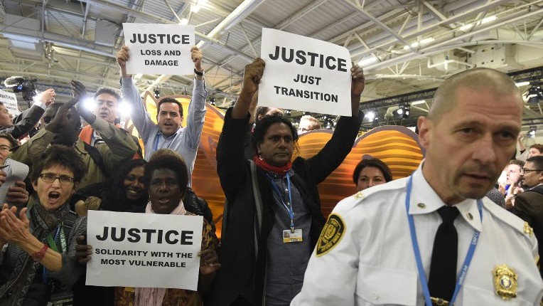 Activists of a non-governmental organization protest with placards during the UN conference on climate change in Le Bourget on the outskirts of Paris