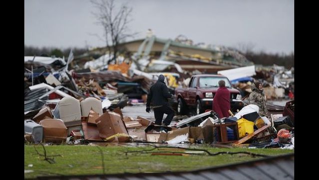 People assess the damage to a storage facility destroyed by Saturday's tornado in Garland Texas Sunday Dec. 27 2015