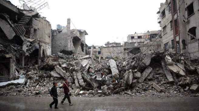 Syrian children walk past the rubble of destroyed buildings in the rebel-held area of Douma east of Damascus