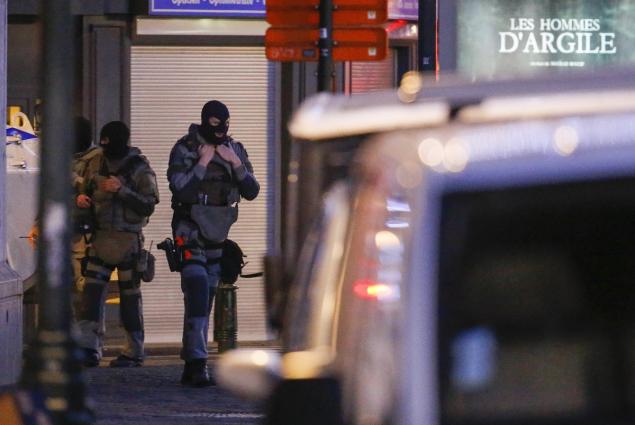 Belgian police officers arrest five people after raids related to the Paris terror attacks