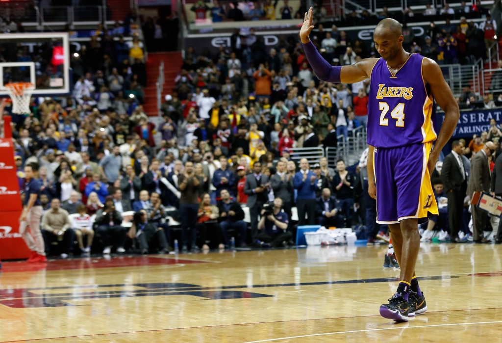 WASHINGTON DC- DECEMBER 02 Kobe Bryant #24 of the Los Angeles Lakers waves to the crowd after his upcoming retirement was announced on the video board during the first half against the Washington Wizards at Verizon Center