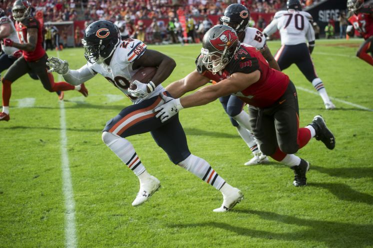 Bears strong safety Harold Jones Quartey slips through the grasp of Bucs guard Ali Marpet during a return after intercepting a pass near the end zone on Sunday. The Bucs forced no turnovers and committed three