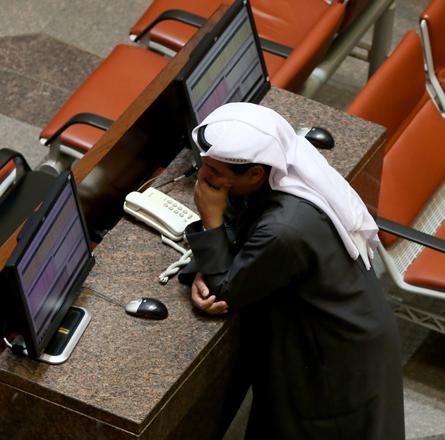 A Kuwaiti trader follows the stock market activity at the Kuwait Stock Exchange in Kuwait City on Sunday