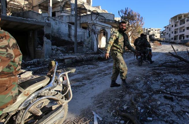 A Syrian army soldier rides a motorcycle in the village of Salma in the northwestern province of Latakia