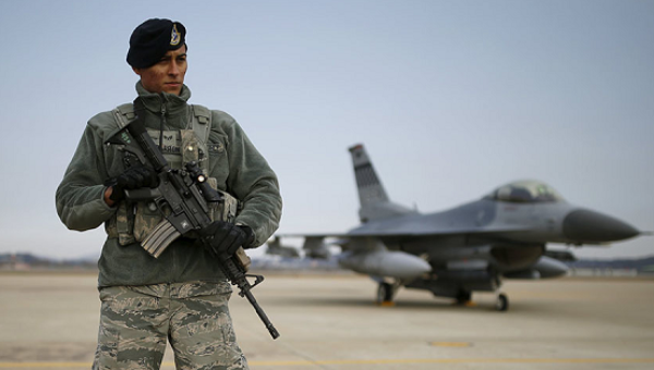 A U.S. soldier stands guard in front of their Air F-16 fighter jet at Osan Air Base in Pyeongtaek South Korea Jan.10 2016