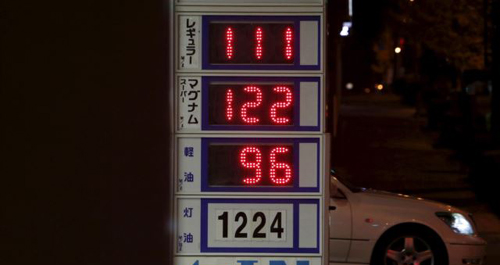 A car passes behind a board posting oil prices at a service station in Tokyo Japan on Dec. 16 2015. /Reuters