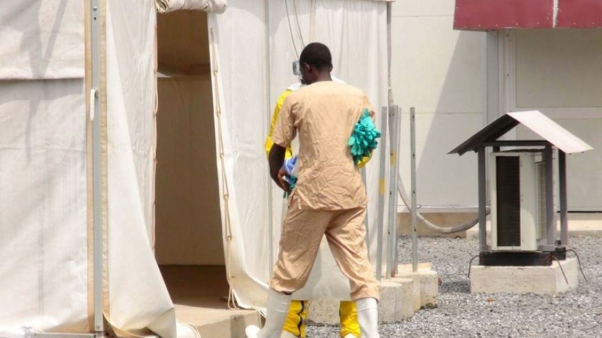 A health worker enters a tent in an Ebola virus treatment center in Conakry Guinea