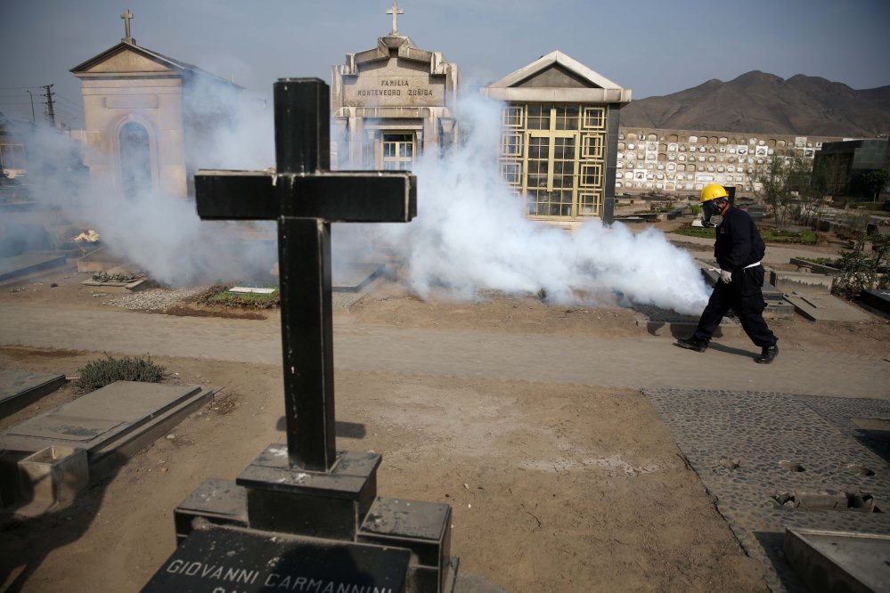 A health worker fumigates to prevent Dengue Chikunguya and Zika virus at a cemetery in Lima Peru