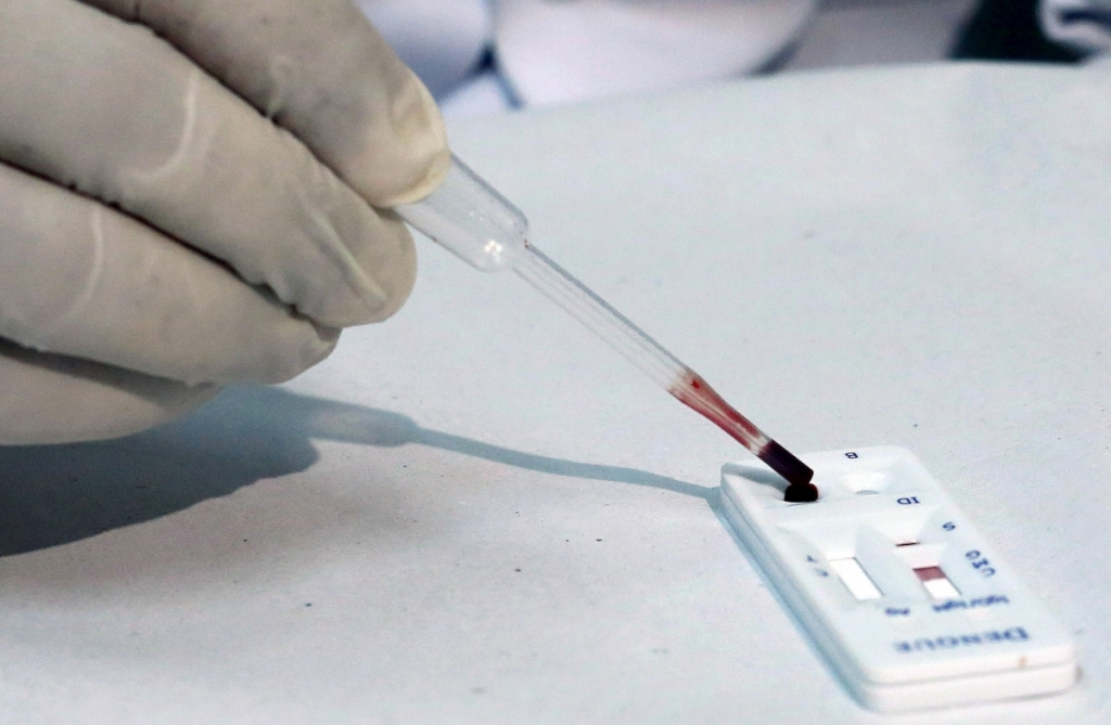 A medical worker tests a blood sample for the Zika virusReuters