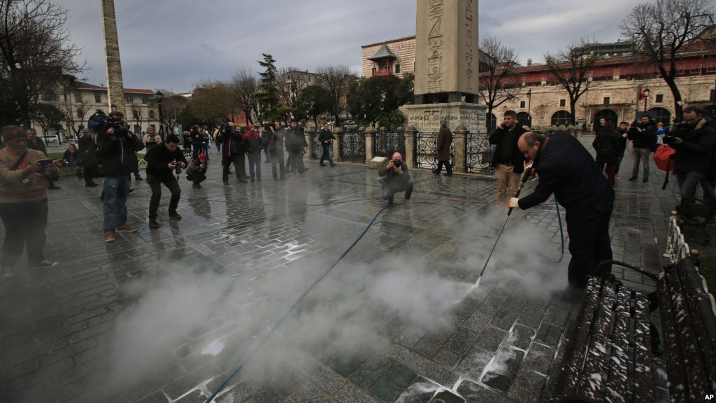 A municipality worker cleans the pavement at the site of Tuesday's explosion in the historic Sultanahmet district in Istanbul Jan. 13 2016