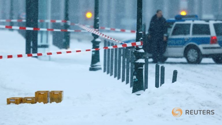 A police car is parked behind suspicious yellow postal crates near the chancellery in Berlin Germany