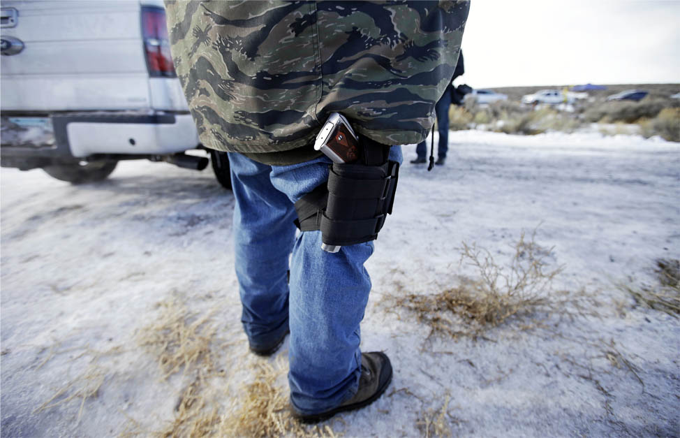 A supporter of the group occupying the Malheur National Wildlife Refuge stands by the front gate