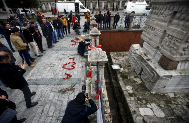 A woman places flowers at the site of Tuesday's suicide bomb attack at Sultanahmet square in Istanbul Turkey