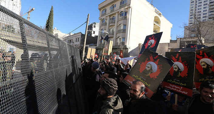 Iranian riot police block a street leading to the Saudi embassy as protesters hold portraits of prominent Shiite Muslim cleric Nimr al Nimr during a demonstration against his execution by Saudi authorities