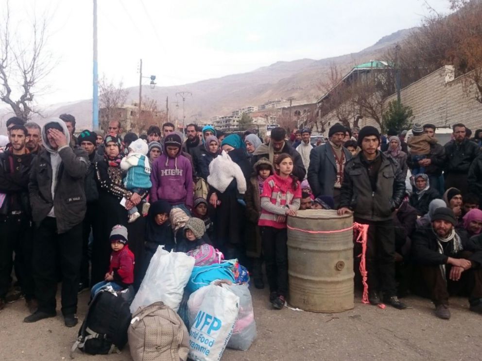 Syrians wait for the arrival of an aid convoy in the besieged town of Madaya Jan. 11 2016