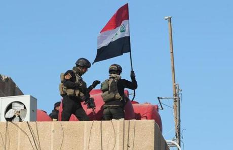 Iraqi forces placed their flag on the roof of a building at the government complex in Ramadi on Monday