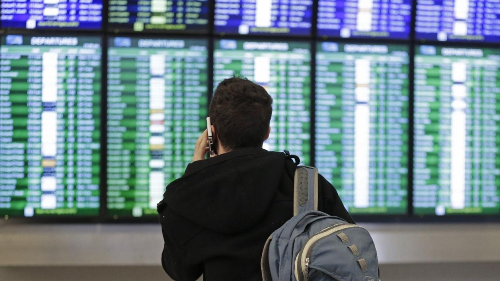 A traveler speaks on the phone as he views the arrival and departure board Friday Jan. 22 2016 at San Francisco International airport in San Francisco