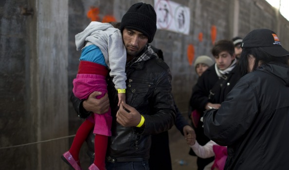 An Afghan man with his daughter after they received wristband tags at Tabakika registration centre Chios island Greece