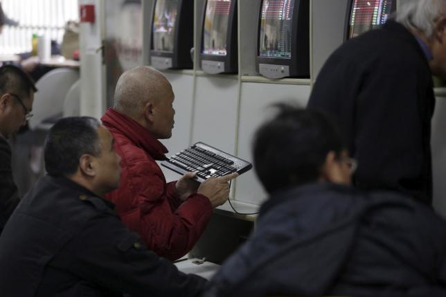 An investor checks stock information on a computer screen at a brokerage house in Shanghai China