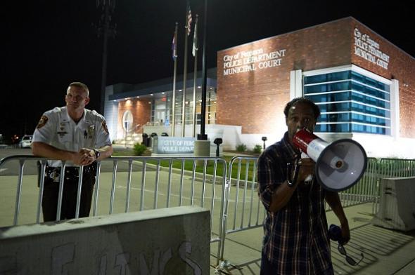 An officer and a protester outside the the Ferguson police department building on Aug. 7 2014. Michael B. Thomas  AFP  Getty Images