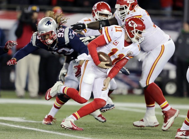 Kansas City Chiefs quarterback Alex Smith scrambles away from New England Patriots defensive lineman Jabaal Sheard in the second half of an NFL divisional playoff football game Saturday Jan. 16 2016 in Foxborough Mass