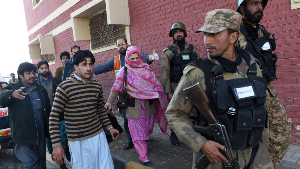 Pakistani soldiers rescue people from Bacha Khan University after an attack by militants in Charsadda Wednesday. At least 20 people died in an armed assault on the university in northwest Pakistan