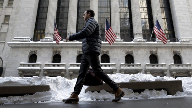 A man passes by a snow pile across from the New York Stock Exchange during the morning commute in Lower Manhattan