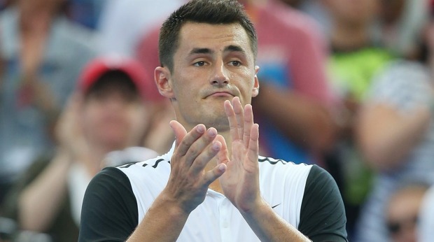 Bernard Tomic waves after losing to Milos Raonic