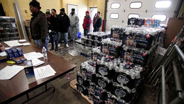 Staff Sergeant William Phillips of Birch Run Michigan helps unload pallets of bottled water at a Flint Fire Station Jan. 13 2016 in Flint Michigan