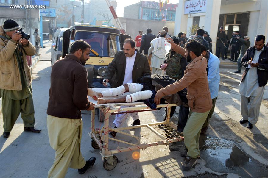 People transfer an injured policeman to a hospital in southwest Pakistan's Quetta Jan. 13 2016. At least 14 security personnel and one civilian were killed and 25 others injured when a blast targeted an anti-polio drive in Quetta city of Pakistan