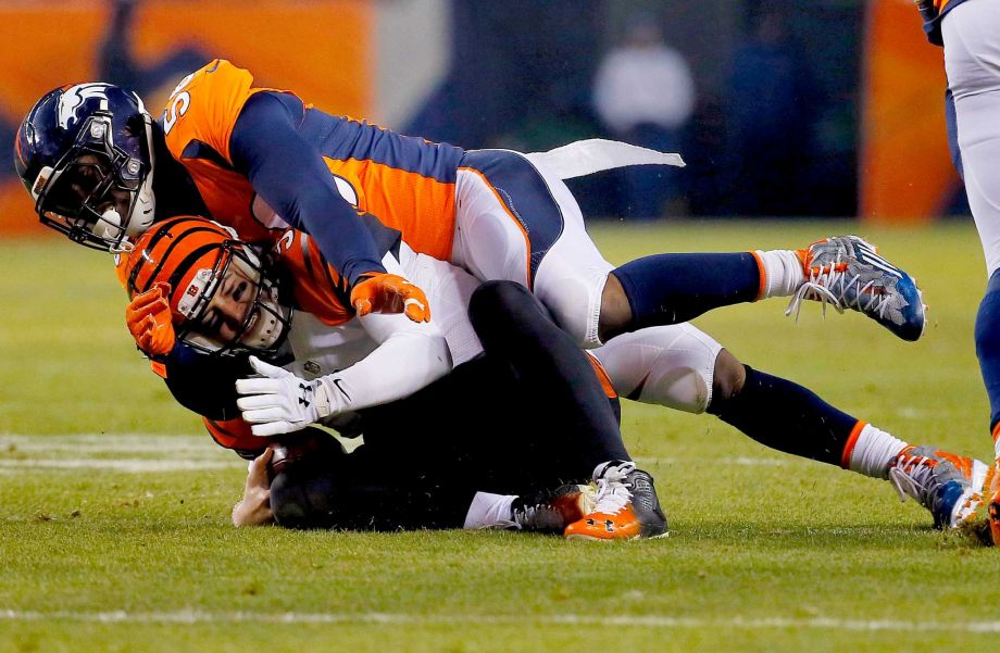 Cincinnati Bengals quarterback AJ Mc Carron his hit as he slides by Denver Broncos linebacker Shane Ray during the first half of an NFL football game Monday Dec. 28 2015 in Denver