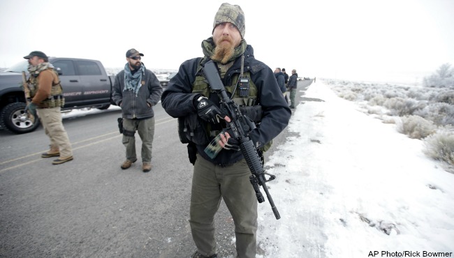 A man stands guard after members of the'3% of Idaho group and several other organizations arrive at the Malheur National Wildlife Refuge near Burns Ore. on Saturday Jan. 9 2016