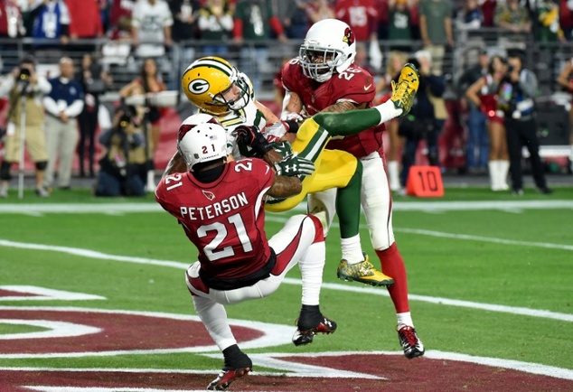 Jeff Janis of the Green Bay Packers hauls in the game-tying pass at the end of regulation while being hit by Patrick Peterson and Rashad Johnson of