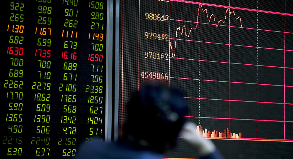 An investor looks at an electronic board displaying stock prices at a brokerage house in Beijing Thursday Jan. 14 2016