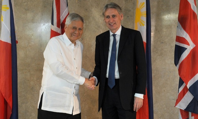 Philippine Foreign Secretary Albert del Rosario shakes hands with his British counterpart Philip Hammond during a visit to the Philippine foreign ministr