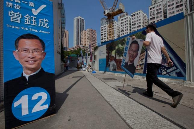 A supporter of candidate Jasper Tsang Yok-sing from the pro Beijing'Democratic Alliance for the Betterment and Progress of Hong Kong  carries a placard of Yok-sing on election day for the Legislative Council in Hong Kong