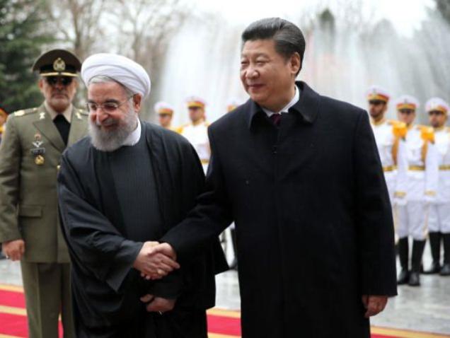 Chinese President Xi Jinping shakes hands with Iranian President Hassan Rouhani in an official arrival ceremony at the Saadabad Palace in Tehran on Saturday. The two leaders agreed to expand economic and political ties calling it