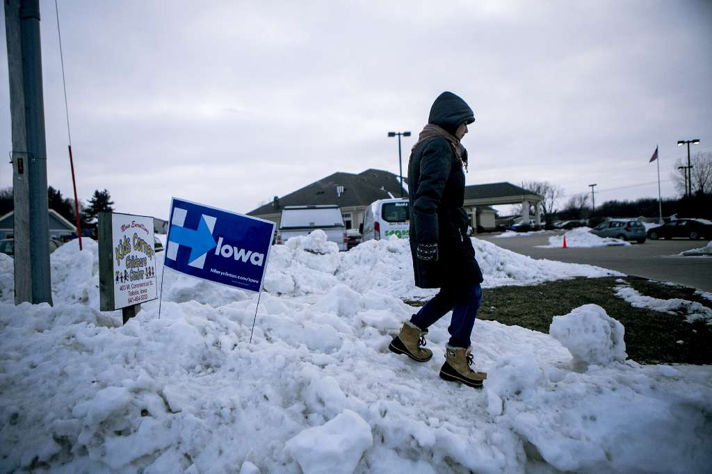 Mara Baron an organizer for Hillary Clinton waits out in the snow to direct cars to parking areas for an event where the Democratic presidential hopeful was speaking in Toledo Iowa Jan. 18 2016