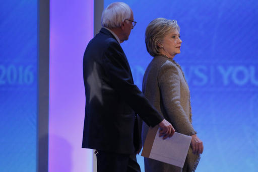 Democratic presidential candidates Bernie Sanders and Hillary Clinton talk as they return to the stage together at the end of a commercial break at presidential debate Manchester N.H. Dec. 19 2015