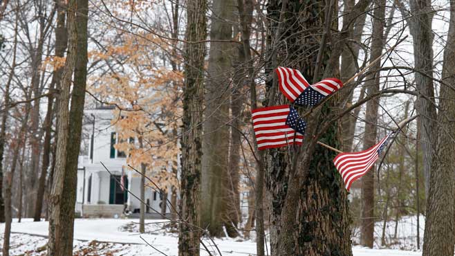 Small American flags have been placed in the trees in front of the Warmbier family home Friday Jan. 22 2016 in Wyoming Ohio. North Korea on Friday announced the arrest of Otto Warmbier a university student from Ohio for what it called a'hostile